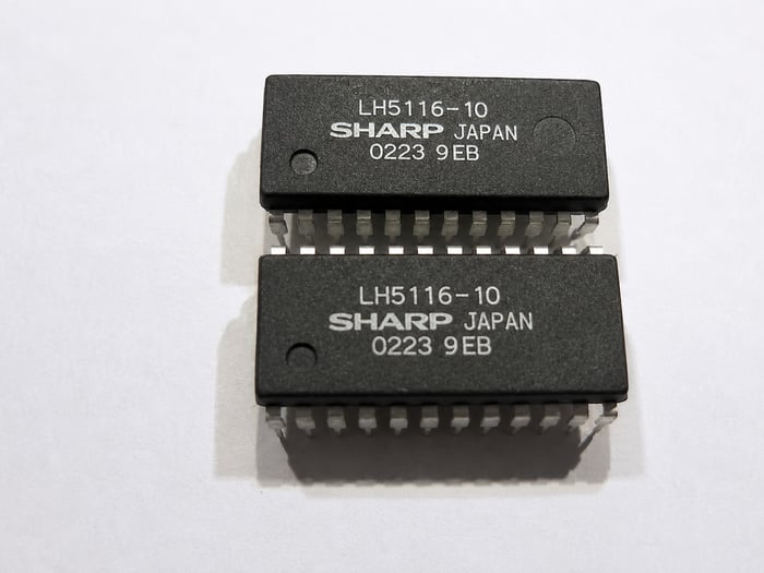 Stacked SHARP LH5116-10 chips showing an indent filled by blacktopping resurfacing
