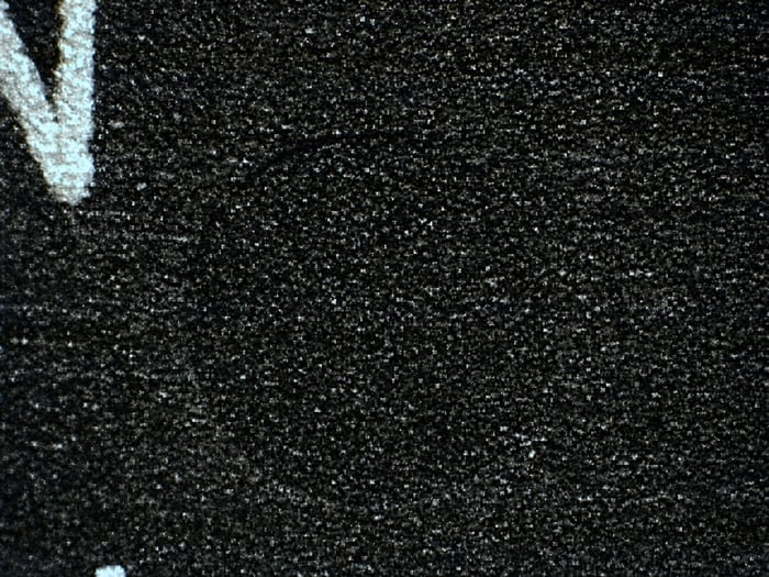 Close-up of a counterfeit HD61602R indent filled to the edge with blacktopping material