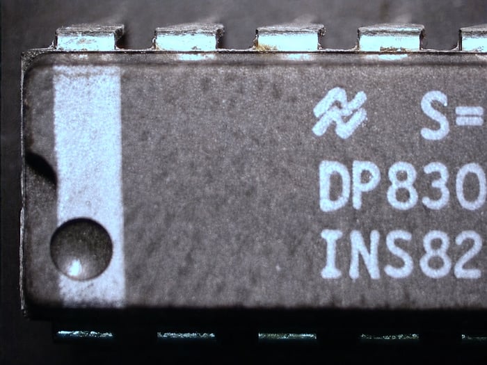 Counterfeit DP8304BN from the same lot code showing one oversized indent and one missing