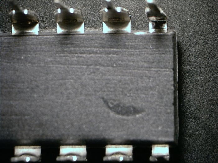 Counterfeit MAX743CPE showing directional sanding marks from remarking preparation