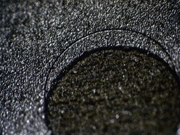 Counterfeit UPD70320L-8 with a faked etched indent whose interior texture does not match the surrounding surface