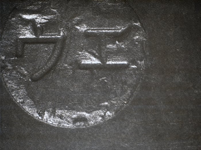 Counterfeit M54459L with remarking material stuck inside the mold indent