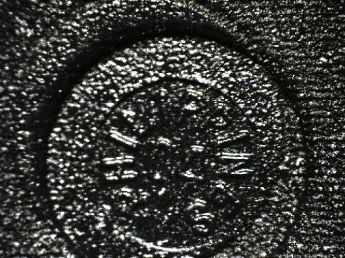 Counterfeit SST28F1040A showing a stamp applied over an existing country-of-origin marking inside the indent